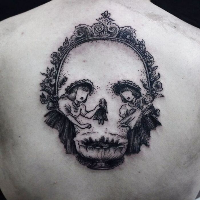Two girls create an optical illusion tattoo, forming a skull with intricate floral details.