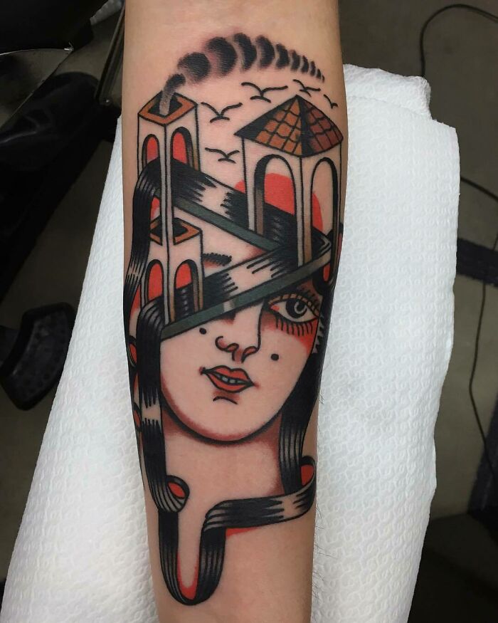 Optical illusion tattoo featuring a woman's face intertwined with architectural designs.