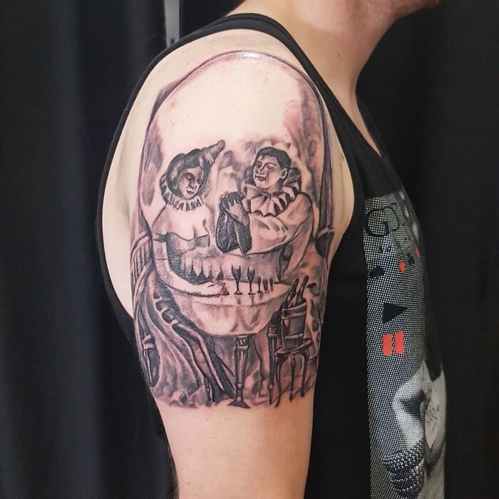 Tattoo featuring an optical illusion of a skull formed by two figures at a table.