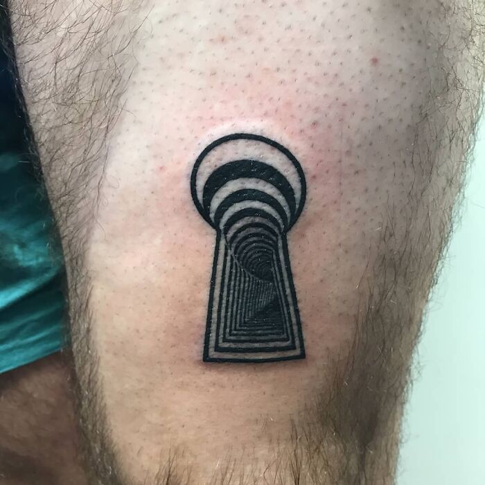Optical illusion tattoo of a keyhole on a person's skin, creating a 3D effect that tricks the eyesight.