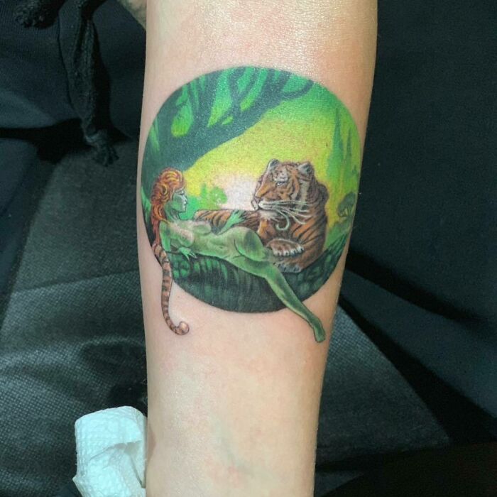 Colorful tattoo of a woman with a tiger in a jungle scene, capturing celebrity tattoo inspiration for a session.