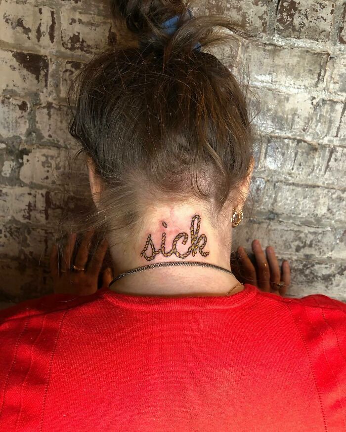 Back of a person's neck with the word "sick" tattooed, wearing a red shirt, against a brick wall. Celebrity tattoos inspiration.