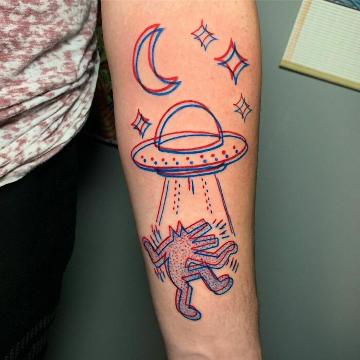 Optical illusion tattoo of a UFO beaming up a figure, surrounded by stars and a crescent moon.