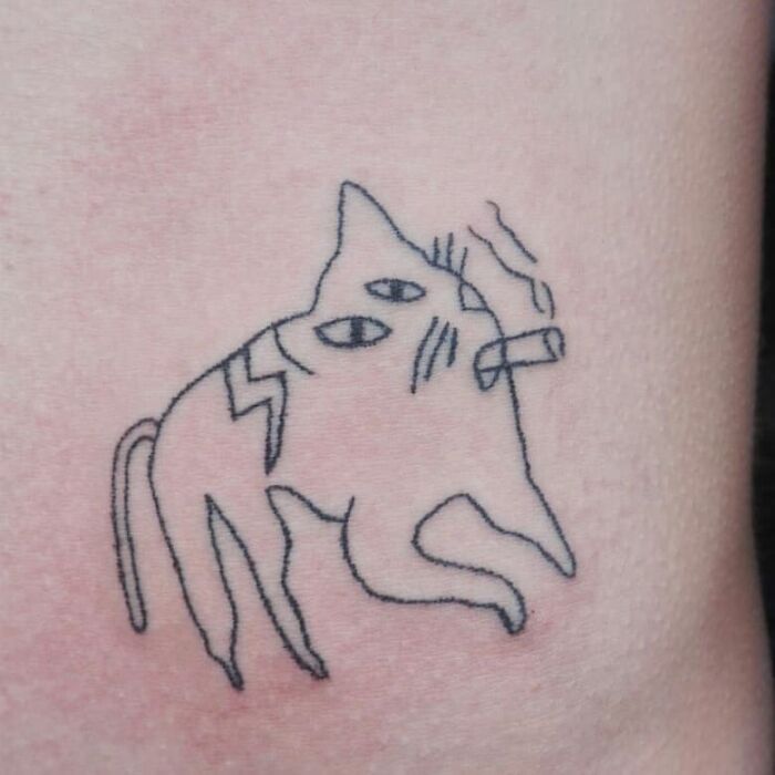Funny cat tattoo with a cigarette, showing off its quirky charm.