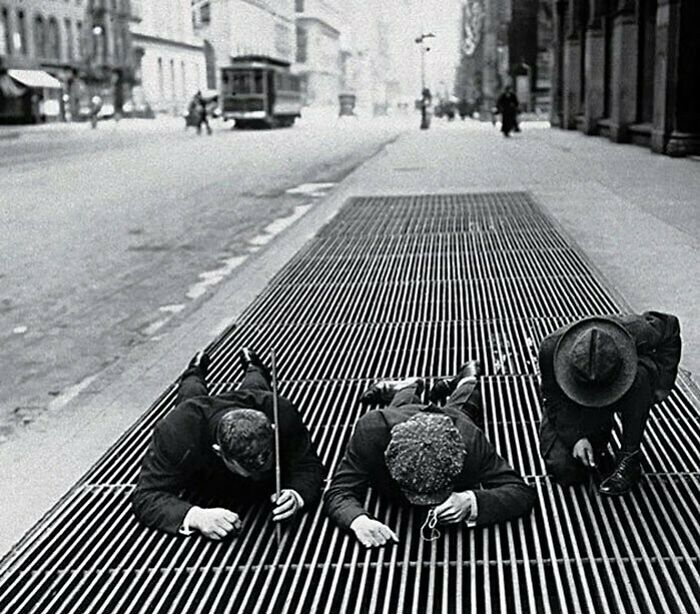 Tres niños pescan monedas durante la Gran Depresión, Nueva York, 1930