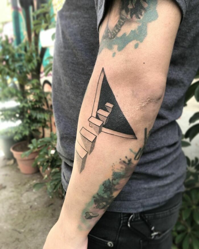 Optical illusion tattoo with a staircase design on a person's forearm, creating a 3D visual effect.