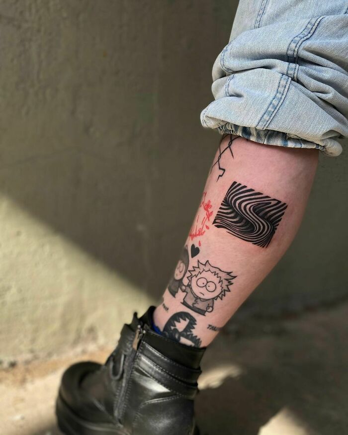 Leg with optical illusion tattoo designs, featuring eye and mind-bending patterns, along with cartoon characters, wearing jeans.