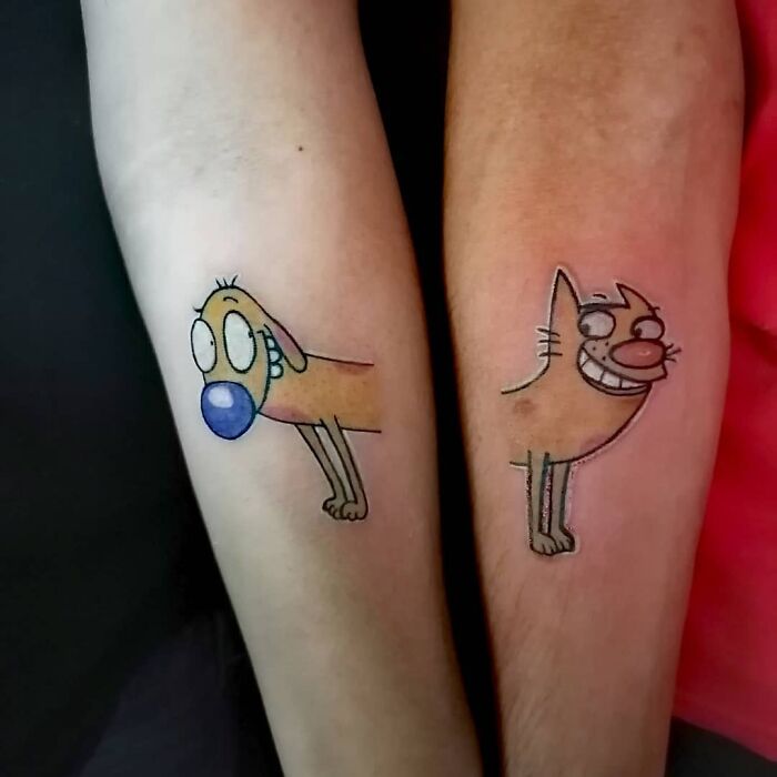 Brother and sister tattoos of cartoon cat and dog on forearms.