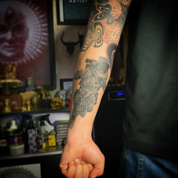 Arm with an optical illusion tattoo, featuring intricate designs, playing tricks on eyesight.