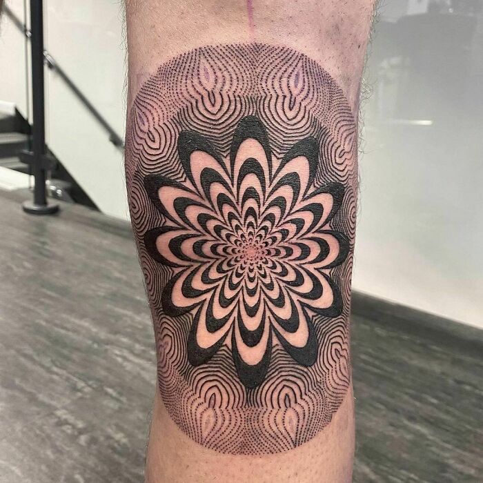 Optical illusion tattoo design with intricate patterns creating a mind-bending effect on a person's leg.