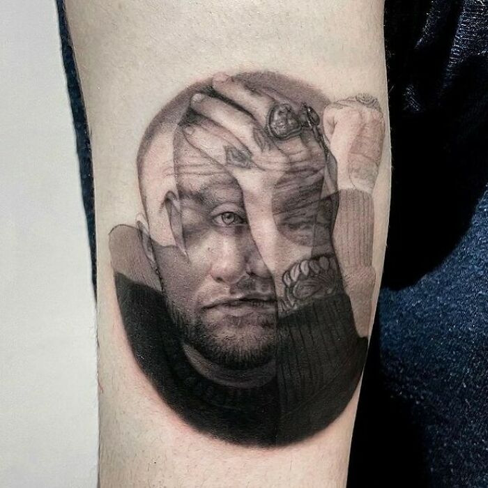 Optical illusion tattoo on arm, depicting a man's face blending with a hand covering an eye, creating a perplexing effect.