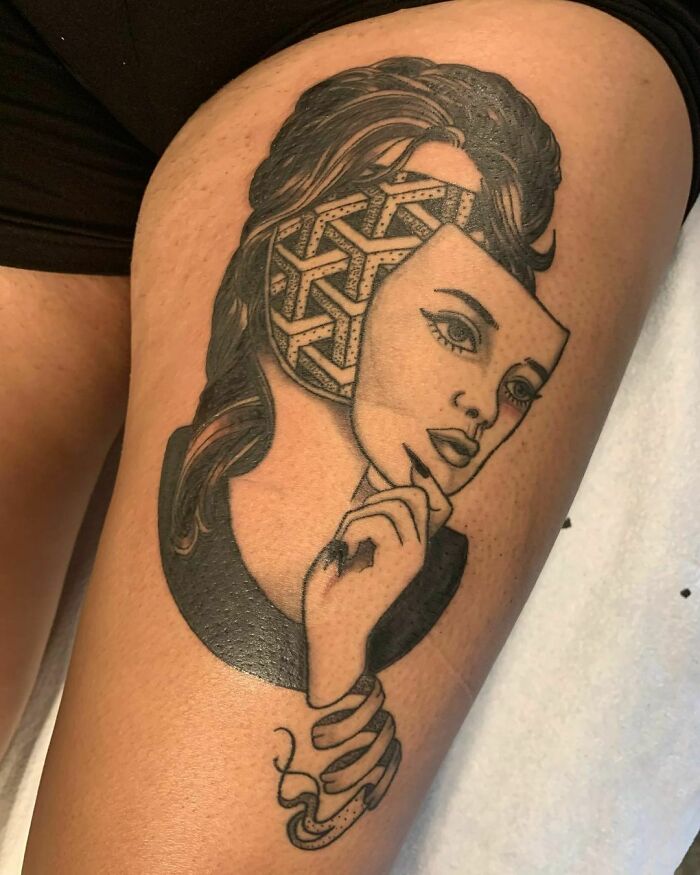 Optical illusion tattoo of a woman revealing geometric patterns under her skin on a person's thigh.