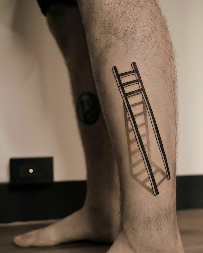 Optical illusion tattoo of a three-dimensional ladder on a man's leg.