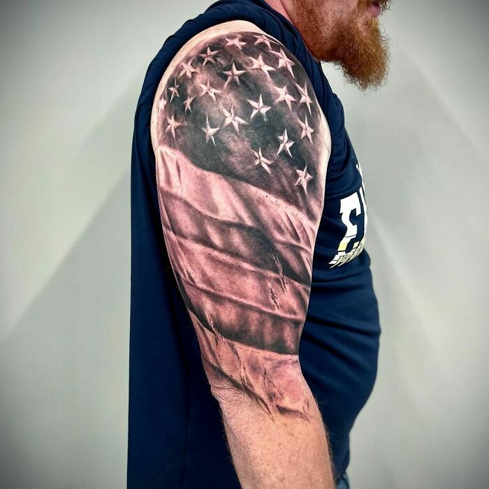 Man with an American flag tattoo on his upper arm, sleeveless shirt.