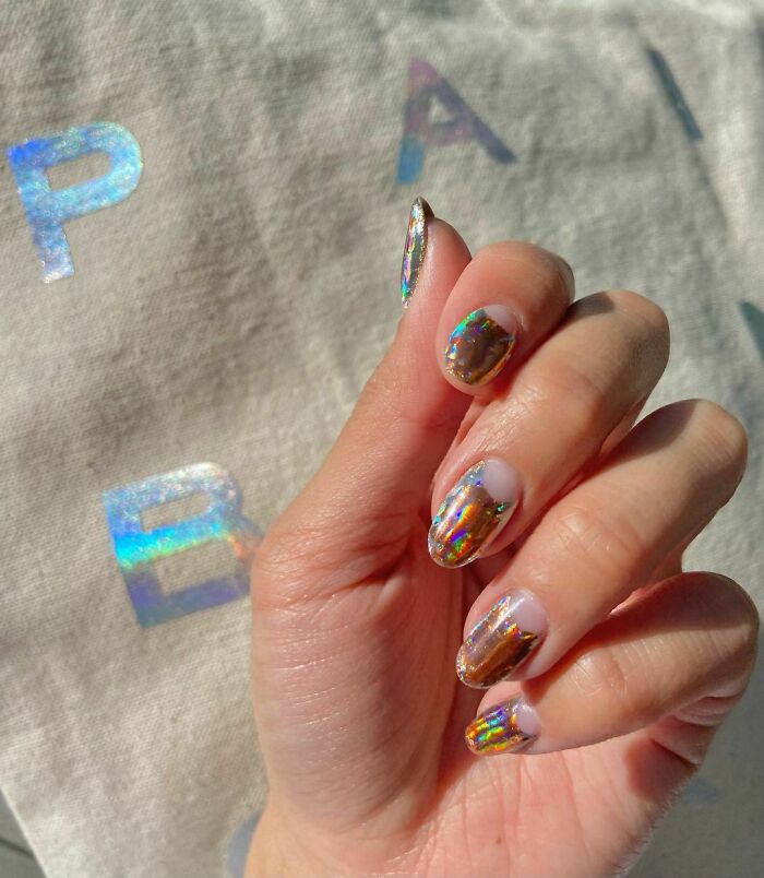 Holographic nail art on fingertips, showcasing a trendy manicure idea.