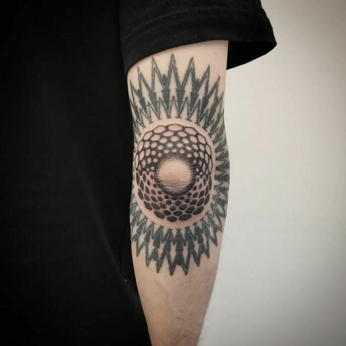 Optical illusion tattoo on forearm, featuring geometric patterns and a 3D effect.