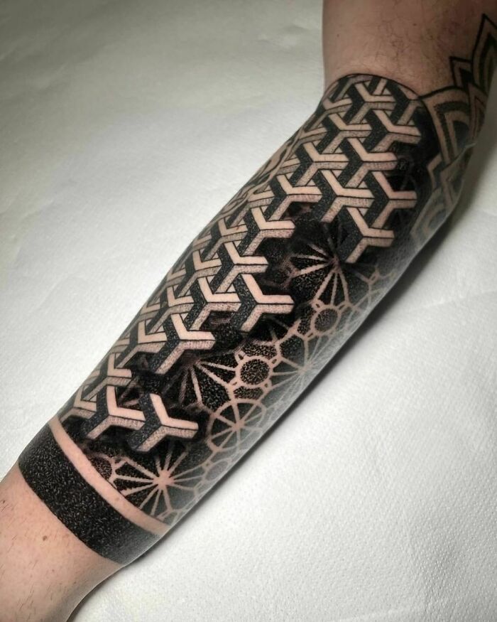 Optical illusion tattoo with geometric, mind-bending design on forearm.