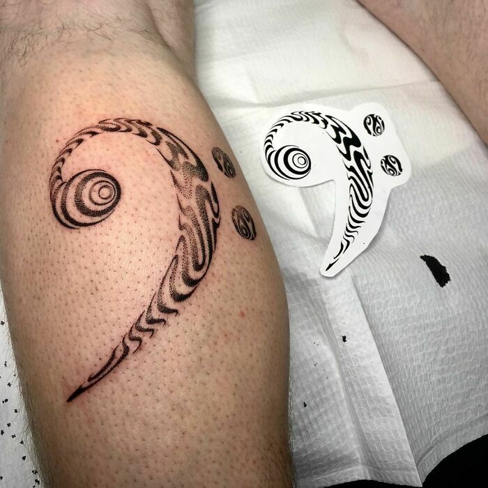 Optical illusion tattoo on a leg, resembling a swirling design next to a stencil.