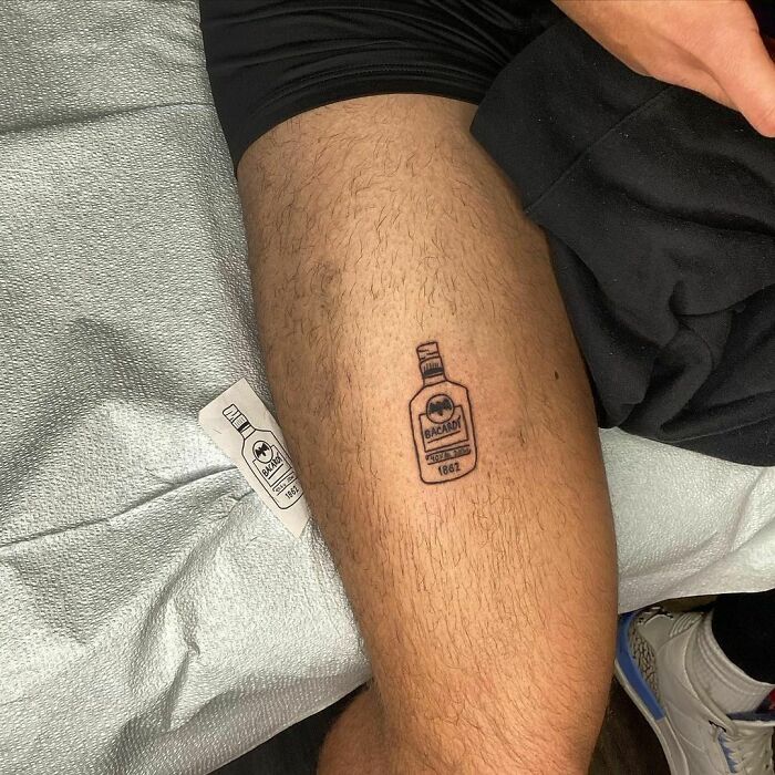 Funny tattoo of a Bacardi bottle on a person's leg.