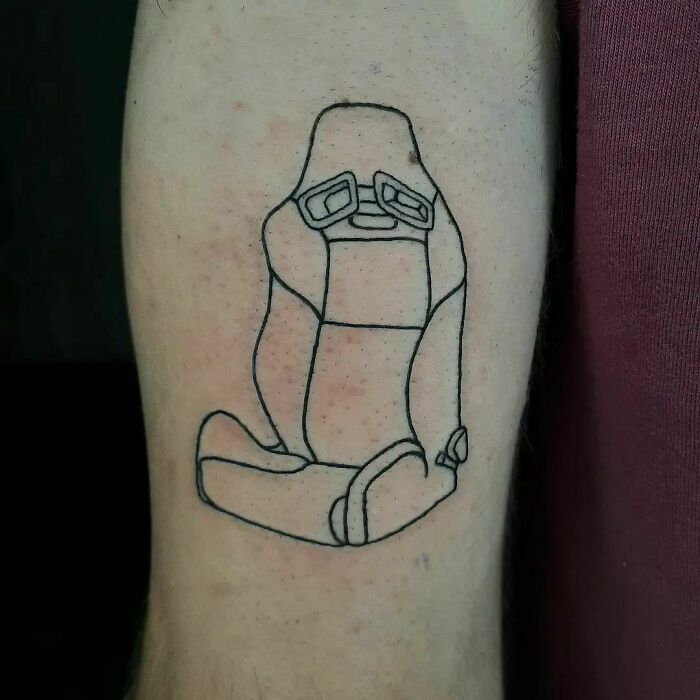 Funny tattoo of a gaming chair without wheels on a person's arm.