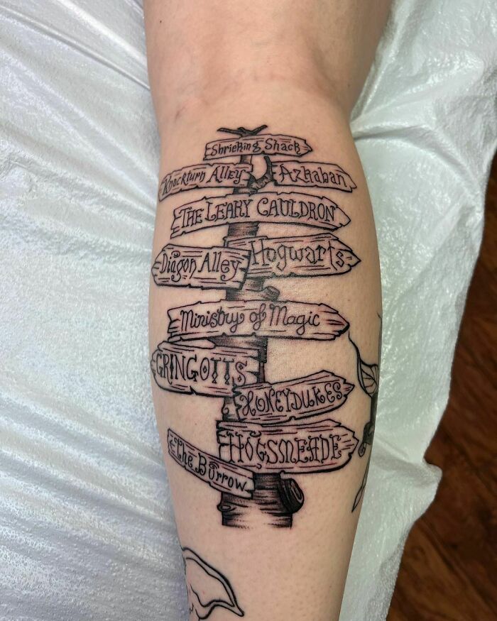 Harry Potter tattoo featuring a detailed signpost with destinations like Hogwarts and Diagon Alley for any Potterhead.