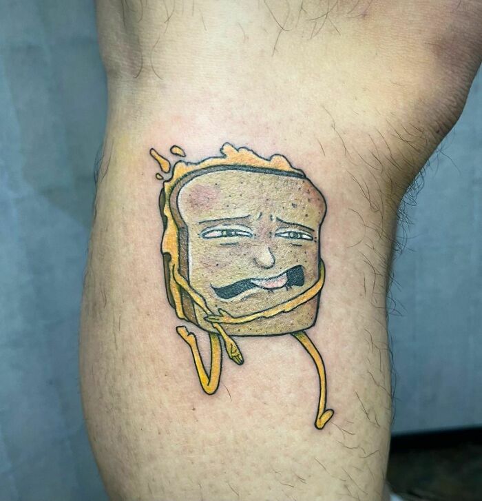 Funny tattoo of a sandwich with a human face and legs, designed to amuse.