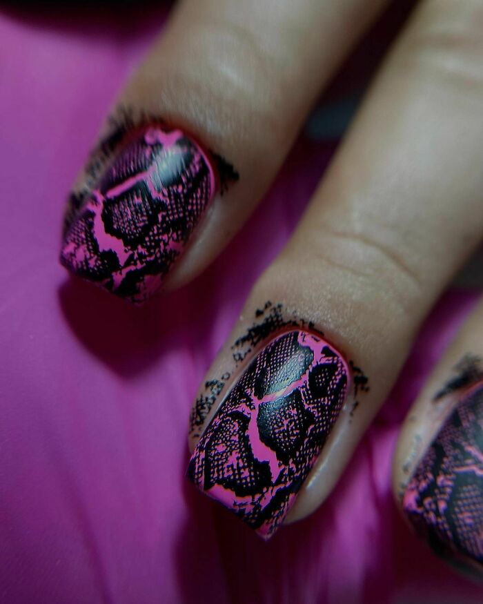 Close-up of nails featuring pink and black detailed nail art designs showcasing creative nail art ideas.
