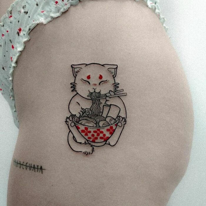 Funny tattoo of a cat eating ramen on a leg.