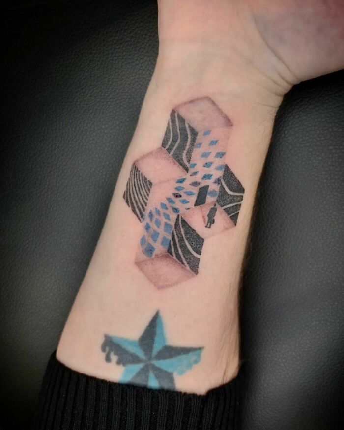Optical illusion tattoo on an arm featuring geometric shapes and color patterns.
