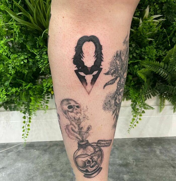 Harry Potter tattoo featuring Snape's silhouette and potion bottle surrounded by greenery.