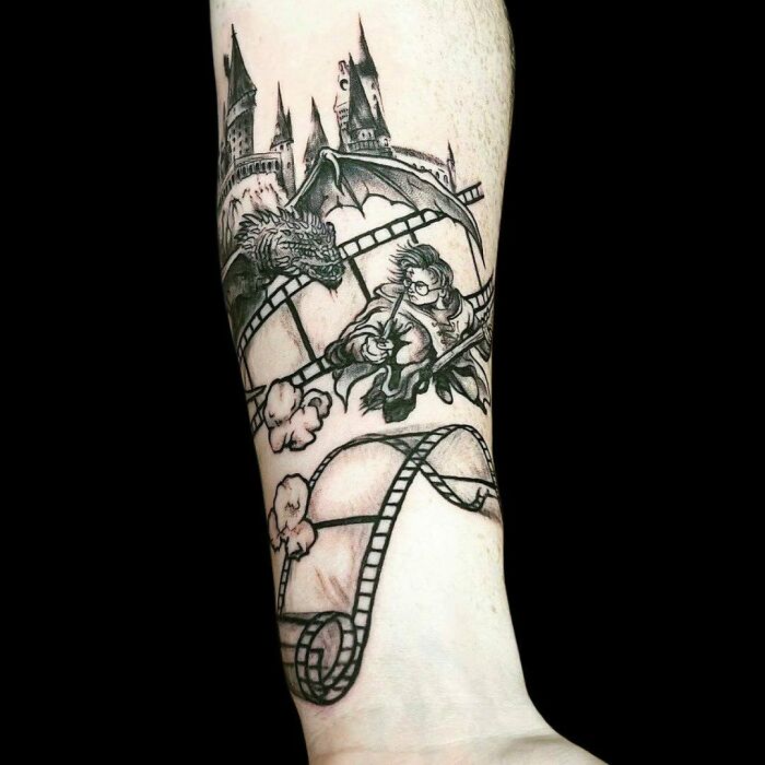 Tattoo featuring Harry Potter elements, including Hogwarts, a dragon, and a broomstick, on a forearm.