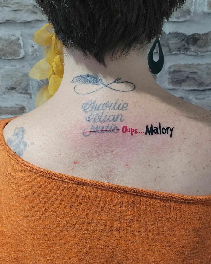 Funny tattoo of crossed-out names on a person's back, highlighting a humorous name mistake.