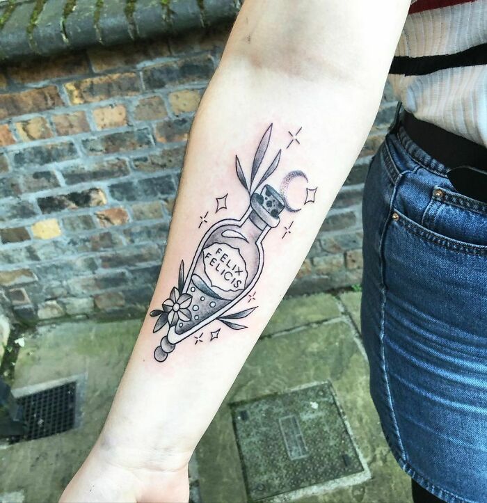 Harry Potter tattoo featuring a Felix Felicis potion bottle on a forearm in black ink.