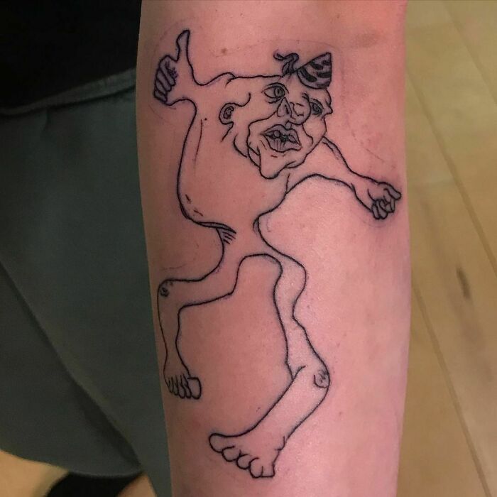 Funny tattoo of a doodle man on an arm, showcasing a whimsical and humorous design.