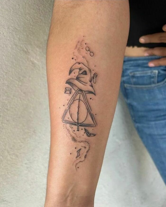 Harry Potter tattoo on forearm featuring Sorting Hat and Deathly Hallows symbol.