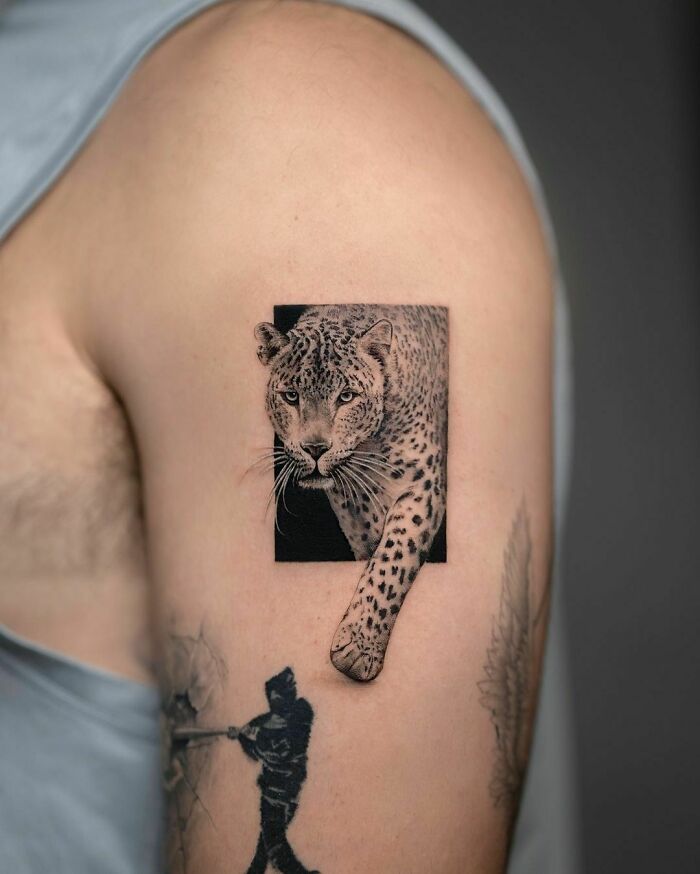 Optical illusion tattoo of a leopard on an arm, designed to appear like it's emerging from the skin.