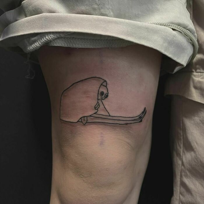 Funny tattoo of a tired little guy on a knee.
