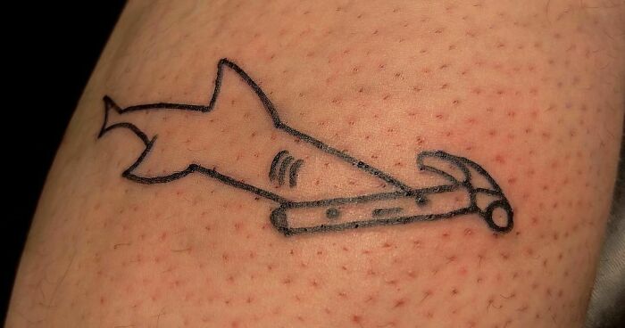 Funny tattoo of a shark with a hammer head on skin.