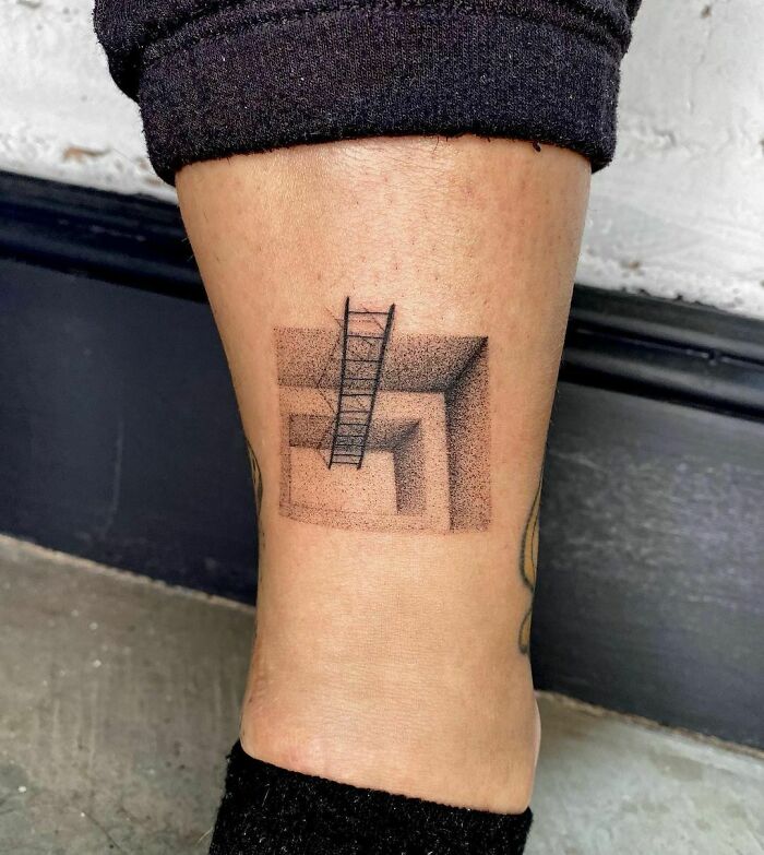 Optical illusion tattoo of a 3D ladder on a person's calf, creating a mind-bending effect.