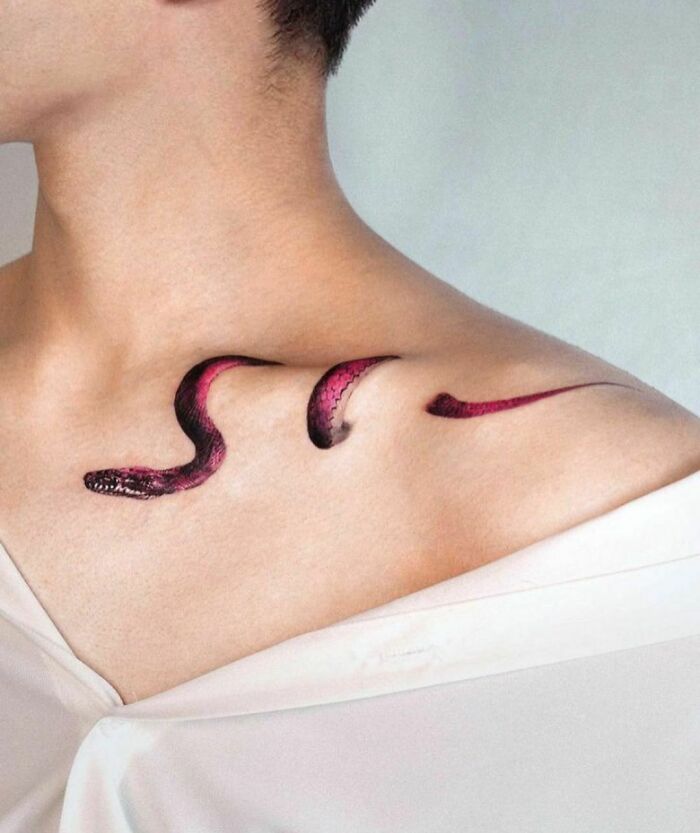 Snake tattoo illusion on shoulder artfully designed, showcasing mind-bending optical style.