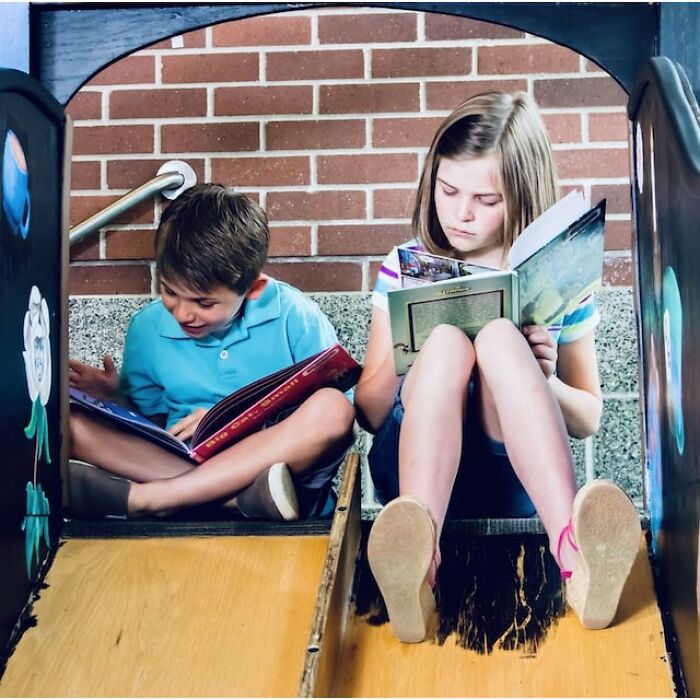 Two children sitting on a slide, reading books, illustrating themes of parenting and child behavior insights.