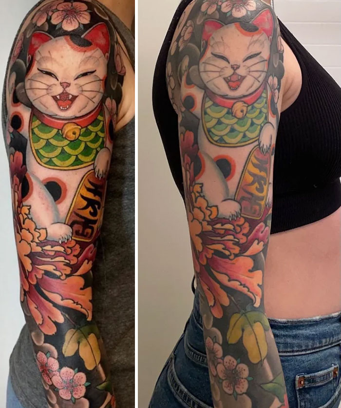 Aged tattoos of a maneki-neko cat on arm, showing changes in ink colors and details over time.