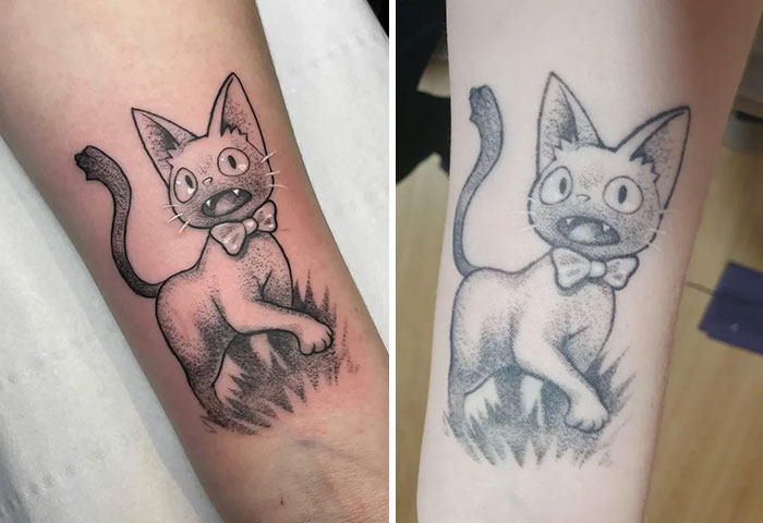 Aged tattoo of a cartoon cat with a bow tie, showing ink changes over the years on forearm.
