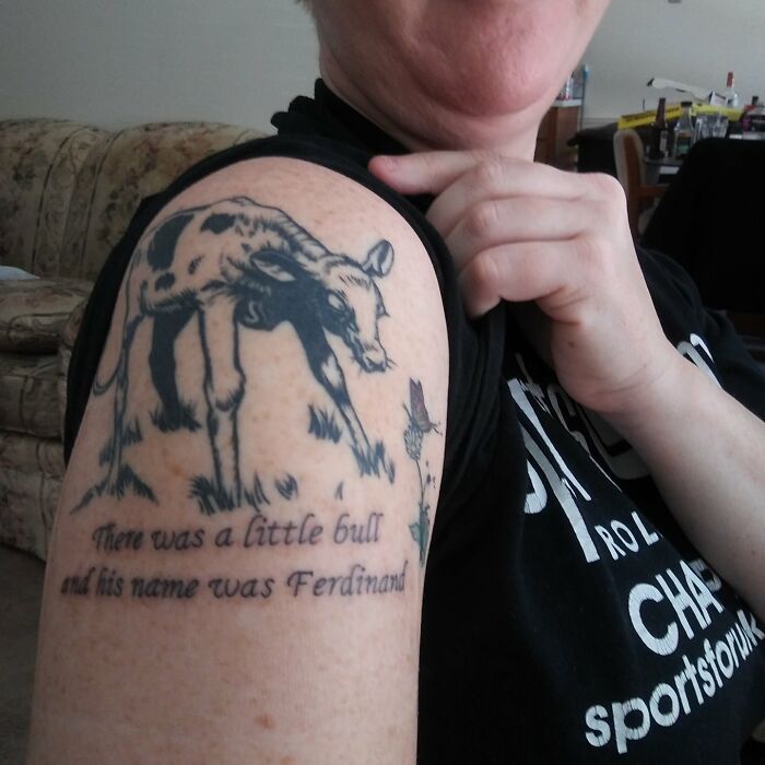 Person showing a tattoo of a little bull named Ferdinand on their arm.