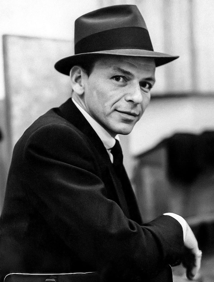 Frank Sinatra wearing black hat and suit, one of the famous people who got married multiple times.