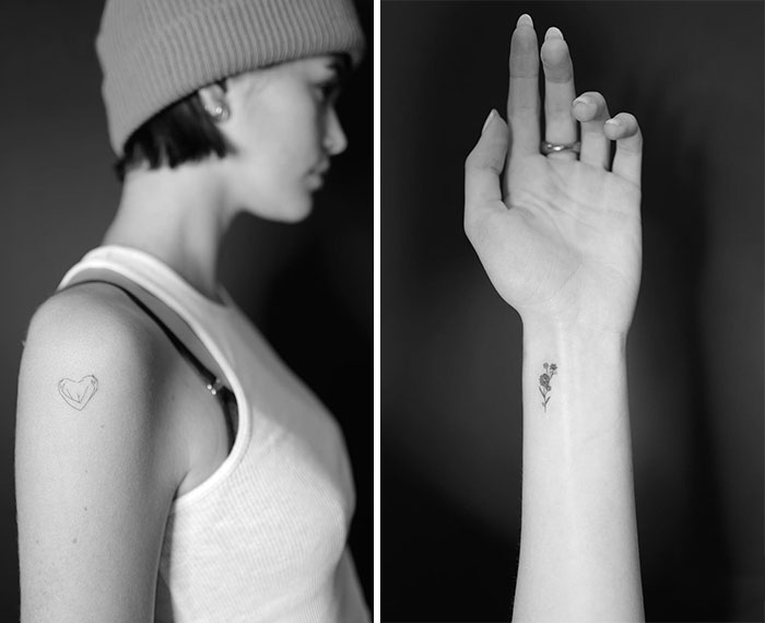Black and white image of celebrity tattoos: a heart on the shoulder and a floral design on the wrist.