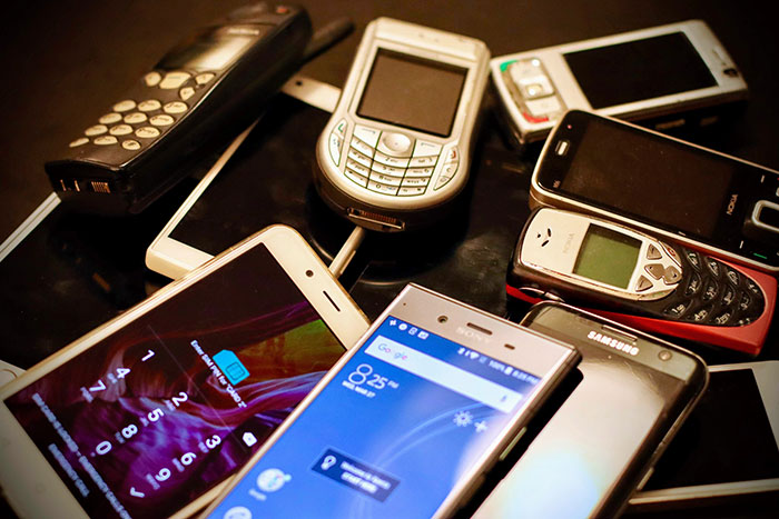 Various old and new mobile phones and smartphones showcasing big trends in mobile technology over time.