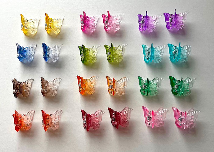 Colorful butterfly hair clips arranged in rows, showcasing big trends in nostalgic fashion accessories.