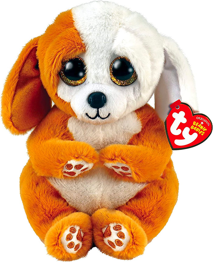 Plush vintage Beanie Baby dog with large glittery eyes and orange and white fur, showcasing popular nostalgic trends.