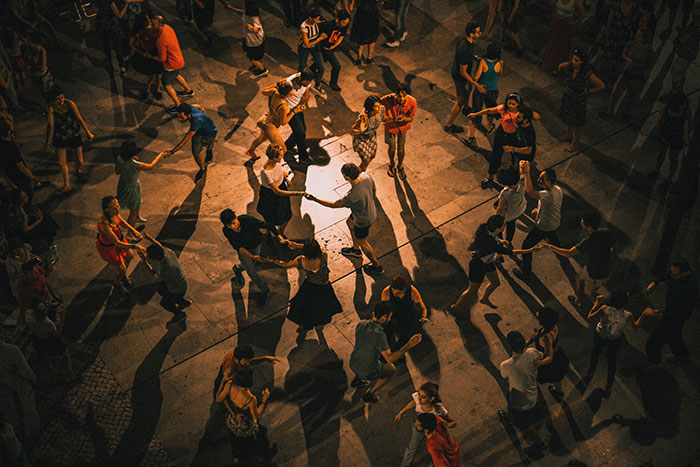 Crowd of people dancing in an outdoor event, showcasing big trends in social gatherings and group activities.